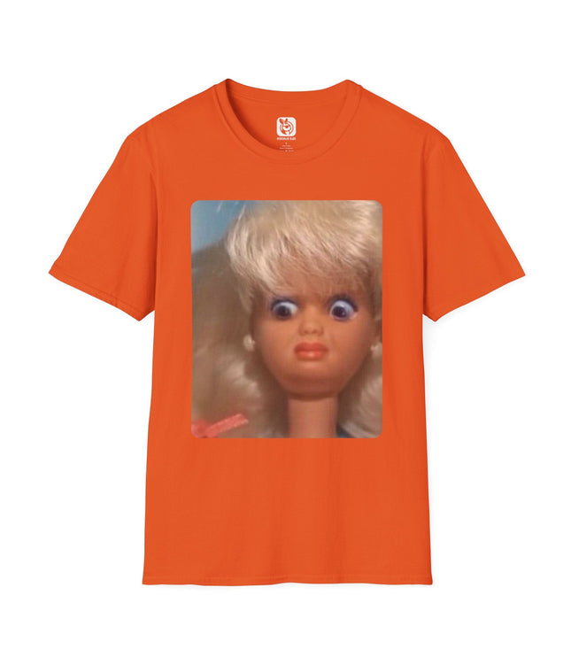Orange t-shirt with a graphic of a doll's face with a disgusted expression